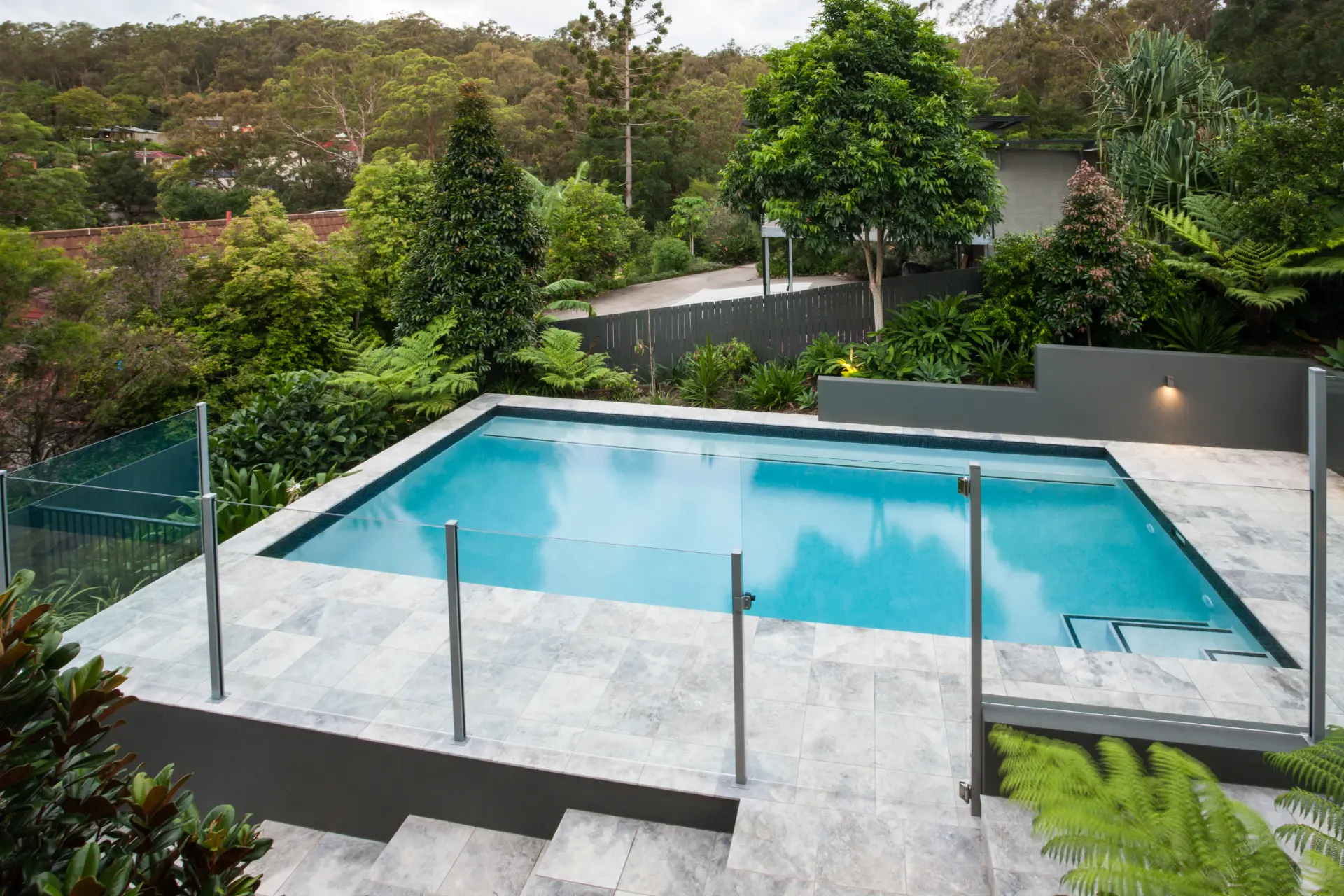 A Wooden Deck With a Metal Fence and a Pool in the Background — Headlands Glass in Ballina, NSW